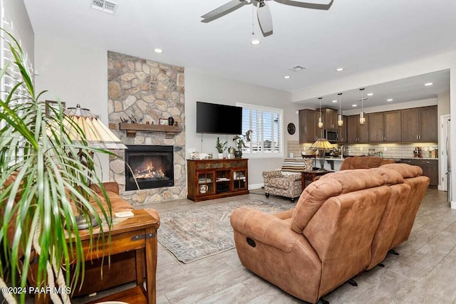 living room featuring ceiling fan and a fireplace