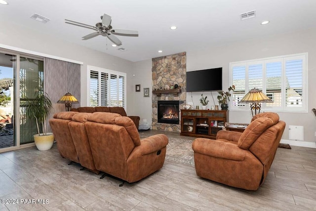 living room featuring ceiling fan and a fireplace