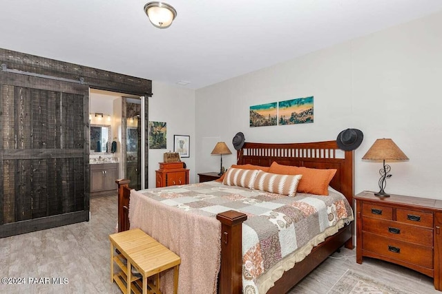 bedroom featuring light hardwood / wood-style floors and ensuite bath