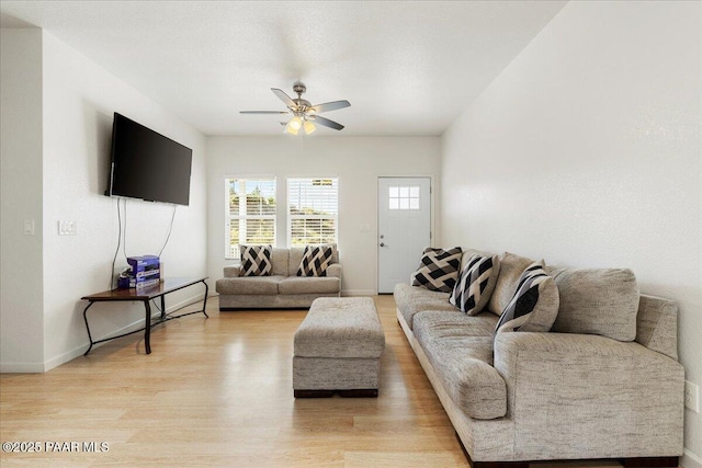living room with a ceiling fan, light wood-style flooring, and baseboards