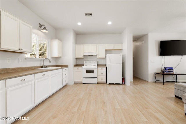 kitchen featuring white appliances, a sink, under cabinet range hood, light wood finished floors, and recessed lighting