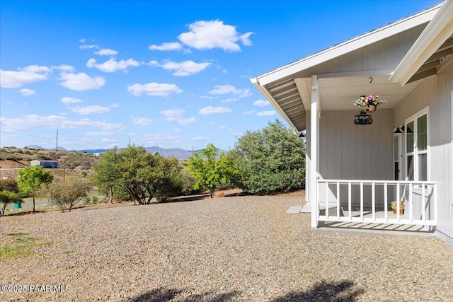 view of yard featuring a mountain view and a porch