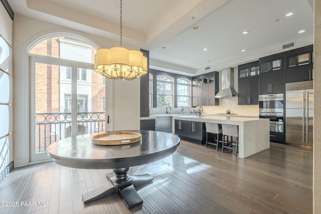 dining room with sink, a raised ceiling, and an inviting chandelier