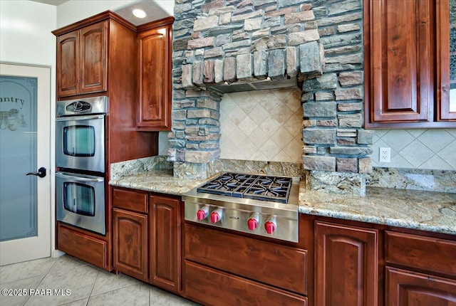 1498 Commonwealth St, Prescott, AZ 86301 - kitchen featuring appliances with stainless steel finishes, backsplash, light stone counters, and light tile patterned floors