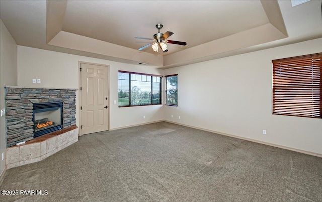 1498 Commonwealth St, Prescott, AZ 86301 - unfurnished living room with a tray ceiling, ceiling fan, carpet flooring, and a fireplace