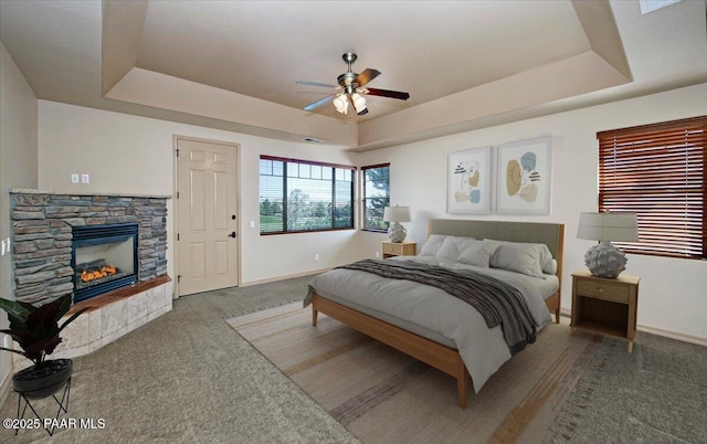 1498 Commonwealth St, Prescott, AZ 86301 - carpeted bedroom with a tray ceiling, a stone fireplace, and a ceiling fan