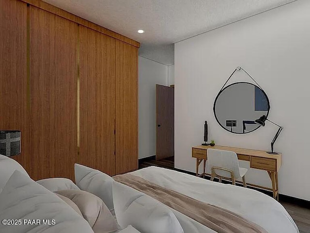 bedroom with dark hardwood / wood-style floors and a textured ceiling