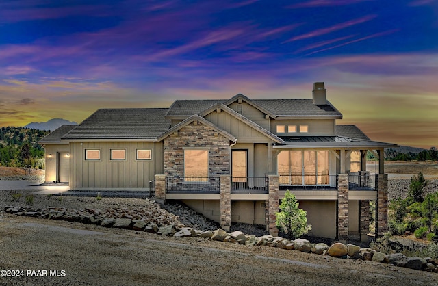 5909 W Cedron Cir, Prescott, AZ 86305 - view of front of house with a chimney, stone siding, a garage, and a balcony