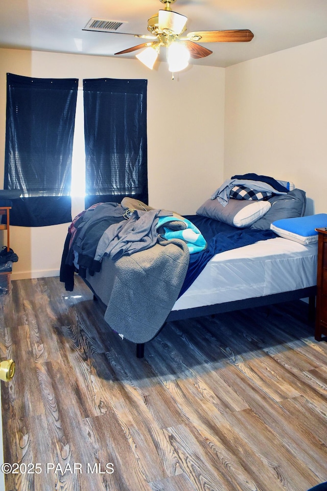 bedroom with visible vents, wood finished floors, and a ceiling fan