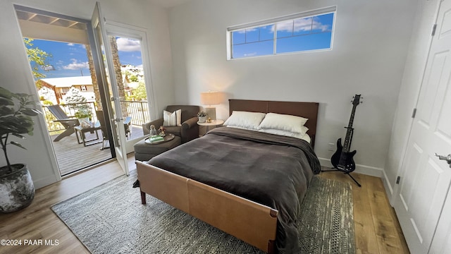 bedroom with hardwood / wood-style floors and access to outside