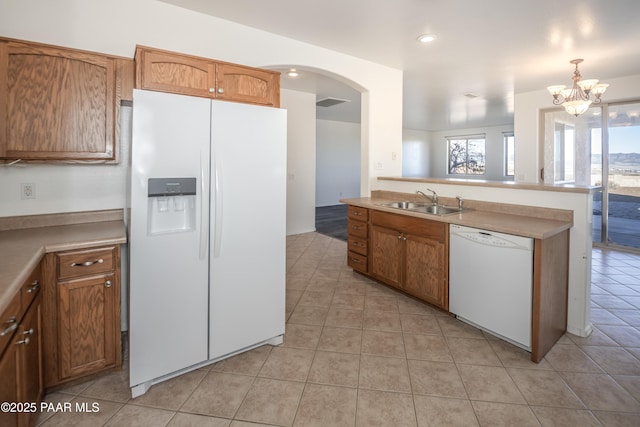 kitchen with pendant lighting, white appliances, sink, and light tile patterned floors