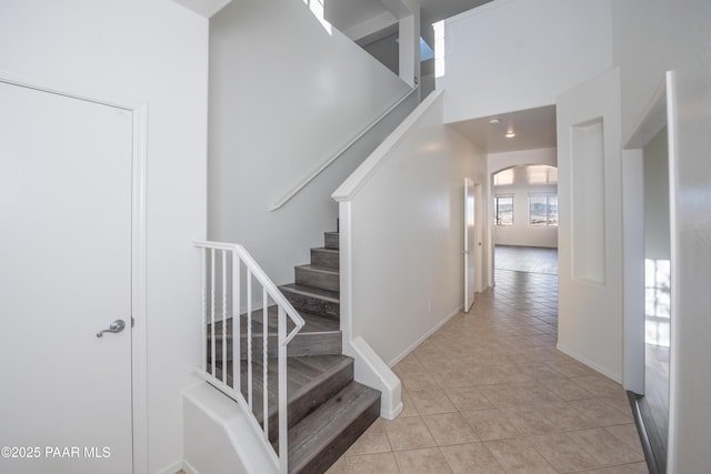 1891 N Tin Strap Trl, Prescott Valley, AZ 86314 - staircase featuring arched walkways, tile patterned flooring, a towering ceiling, and baseboards