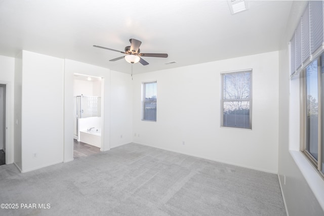 unfurnished bedroom with ceiling fan, ensuite bathroom, and light colored carpet