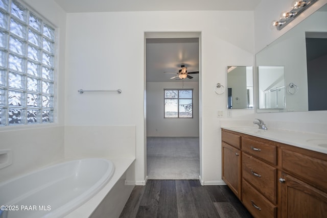 bathroom featuring hardwood / wood-style flooring, vanity, a washtub, and ceiling fan