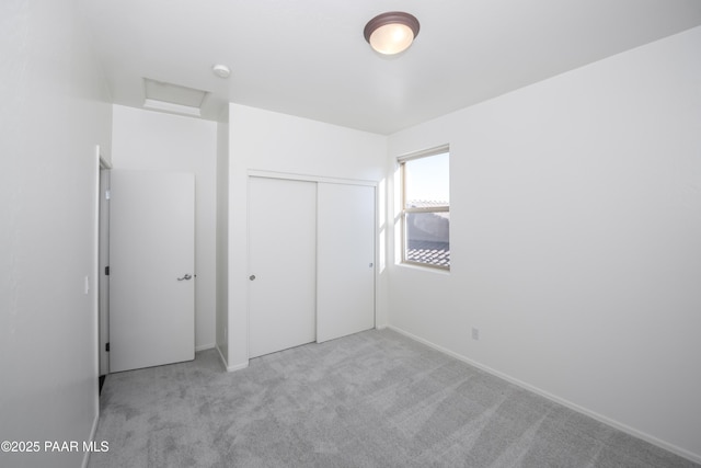 unfurnished bedroom with light carpet and a closet