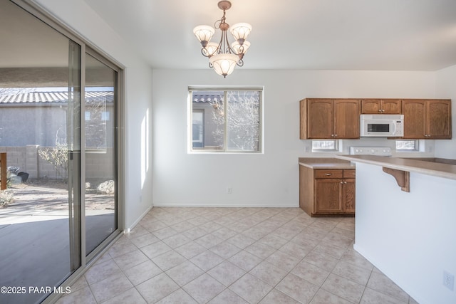 kitchen featuring light tile patterned floors, hanging light fixtures, and a wealth of natural light