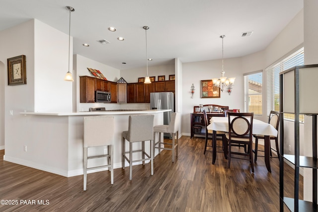 6286 E Livingston Loop, Prescott Valley, AZ 86314 - kitchen with stainless steel appliances, dark wood-style floors, light countertops, recessed lighting, and a kitchen breakfast bar