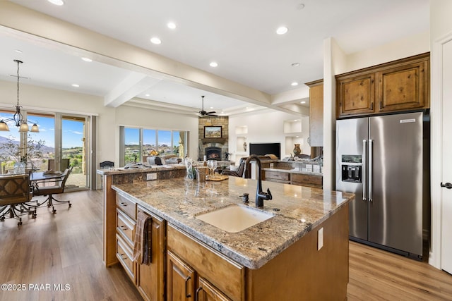 1032 Vantage Point Cir, Prescott, AZ 86301 - kitchen featuring high end refrigerator, a sink, beam ceiling, a fireplace, and a center island with sink