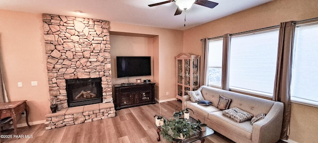 living room with ceiling fan, light hardwood / wood-style floors, and a fireplace