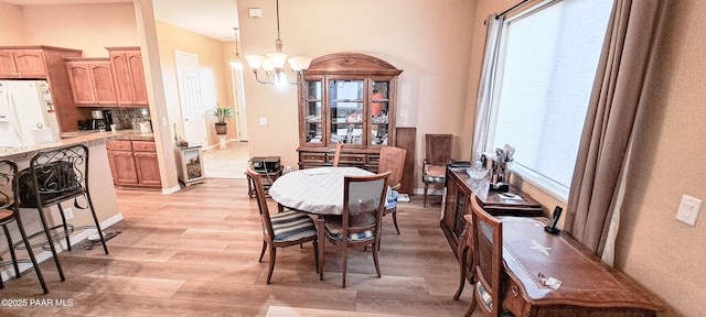 dining room featuring a notable chandelier and light wood-type flooring