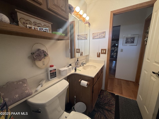 bathroom featuring wood-type flooring, toilet, and vanity