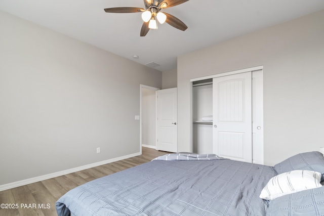 bedroom with dark wood-type flooring, ceiling fan, and a closet