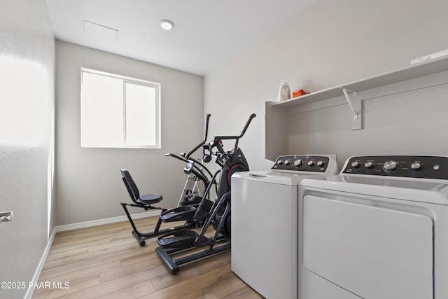 clothes washing area with washer and clothes dryer and light hardwood / wood-style floors