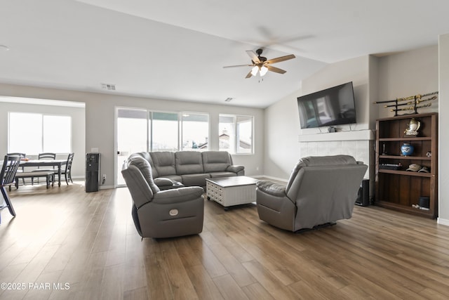 living room with hardwood / wood-style flooring, lofted ceiling, and ceiling fan