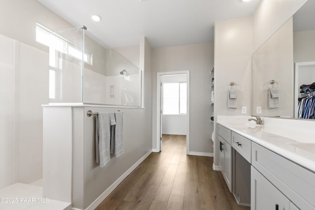 bathroom with vanity, wood-type flooring, and walk in shower