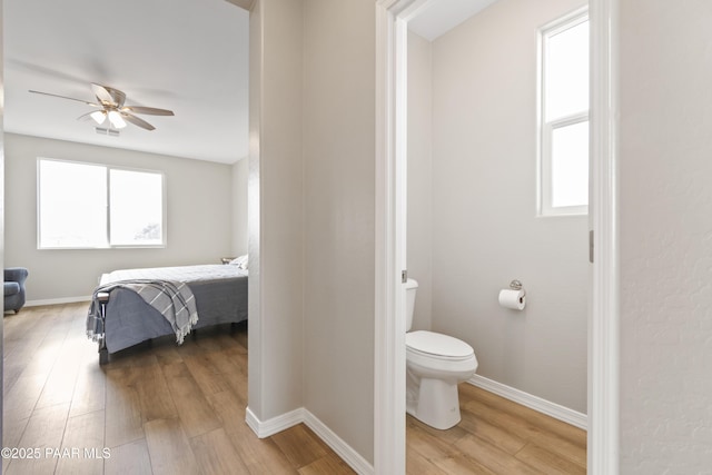 bathroom with wood-type flooring, ceiling fan, and toilet