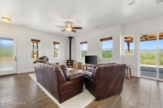 749 S Montezuma St, Prescott, AZ 86303 - living room featuring a wood stove, wood finished floors, a ceiling fan, and plenty of natural light