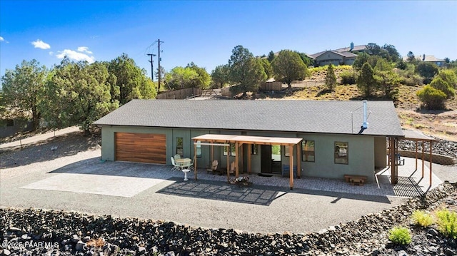 749 S Montezuma St, Prescott, AZ 86303 - rear view of house featuring driveway, an attached garage, stucco siding, and a patio