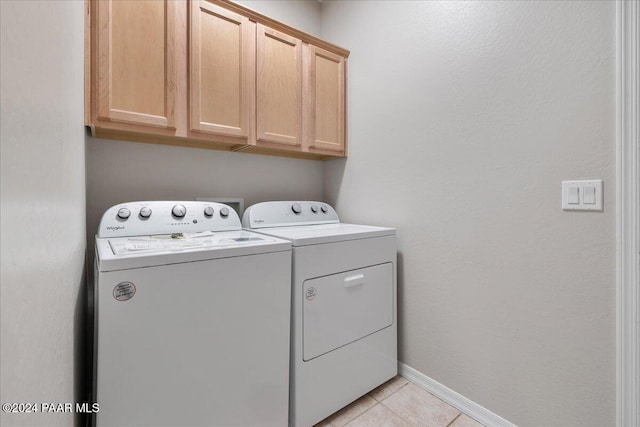 laundry room featuring light tile patterned flooring, cabinets, and independent washer and dryer