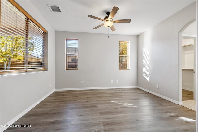 empty room with dark hardwood / wood-style floors and ceiling fan