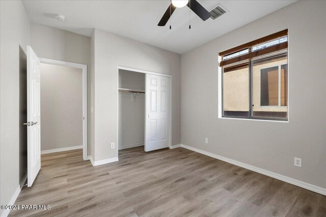 unfurnished bedroom with ceiling fan, a closet, and light hardwood / wood-style flooring