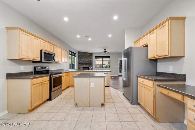 kitchen with ceiling fan, a center island, stainless steel appliances, and light brown cabinets