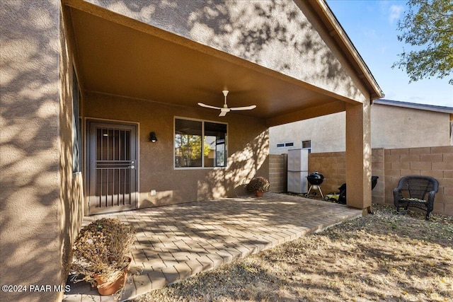 entrance to property featuring ceiling fan and a patio area