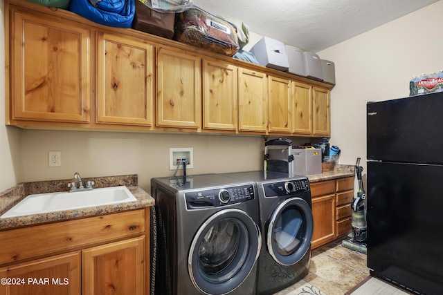 washroom featuring a textured ceiling, cabinets, independent washer and dryer, and sink