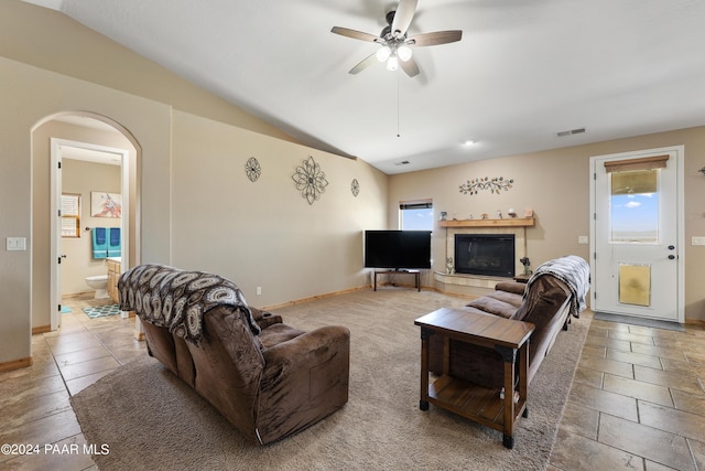 living room with ceiling fan, a wealth of natural light, and vaulted ceiling