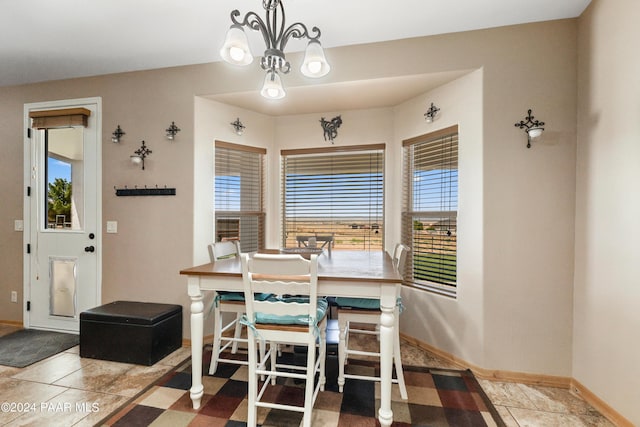 dining room with tile patterned flooring, an inviting chandelier, and plenty of natural light