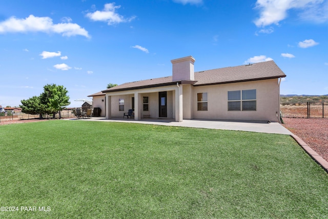 rear view of property featuring a lawn and a patio