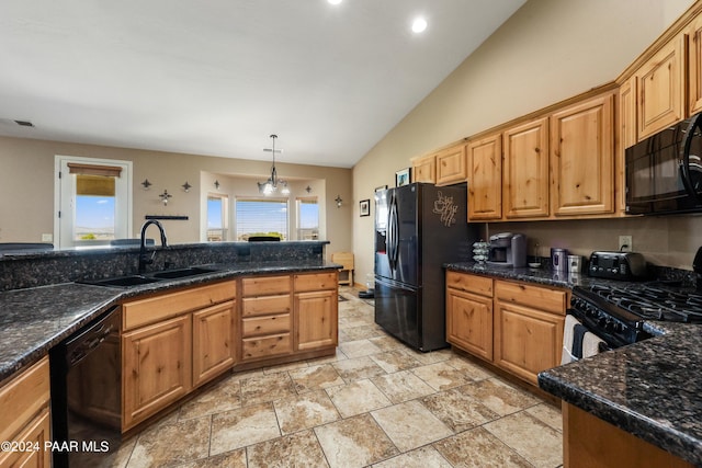 kitchen with pendant lighting, black appliances, sink, vaulted ceiling, and dark stone countertops