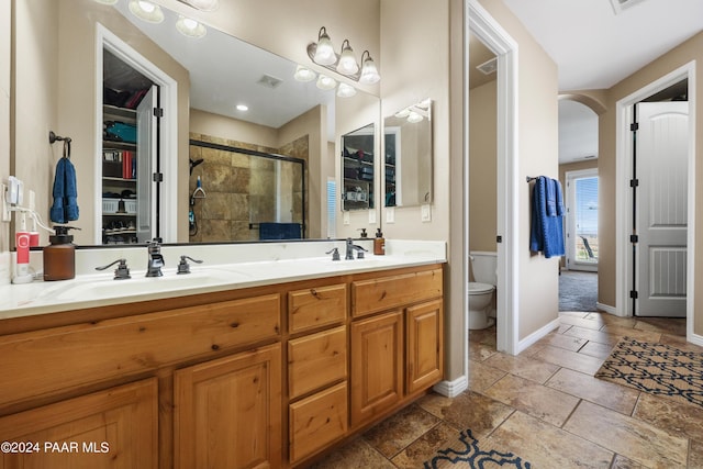 bathroom with vanity, toilet, and a shower with shower door