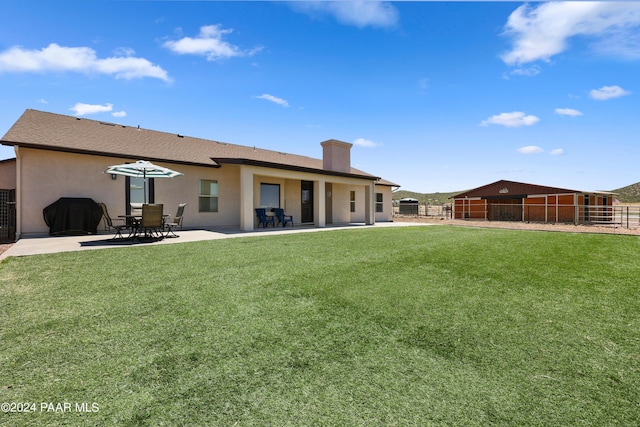 rear view of property with a lawn and a patio area