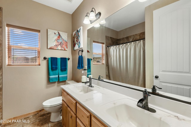 bathroom with tile patterned flooring, vanity, a healthy amount of sunlight, and toilet