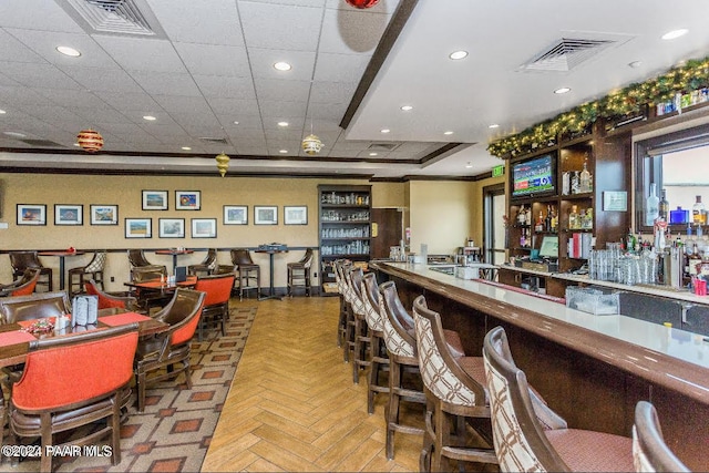 bar with parquet floors and ornamental molding