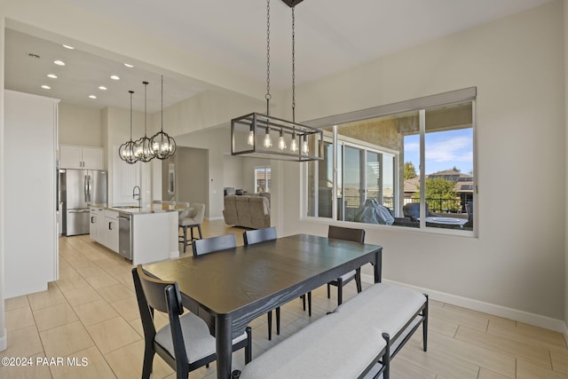 dining room featuring sink, a wealth of natural light, and a chandelier