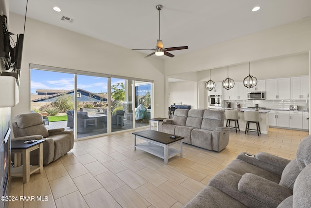 living room featuring ceiling fan with notable chandelier