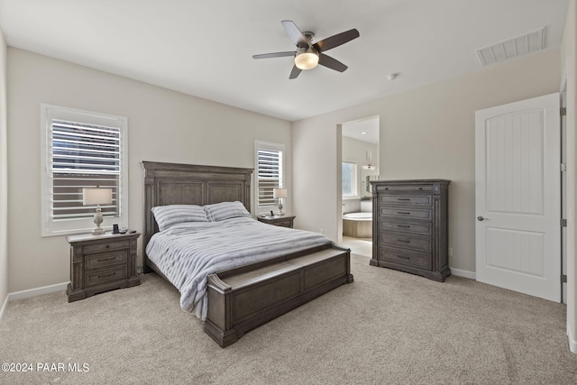 bedroom featuring ensuite bathroom, ceiling fan, and light colored carpet