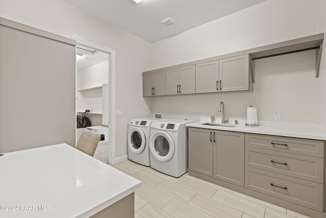 laundry area with washer and clothes dryer, cabinets, and sink